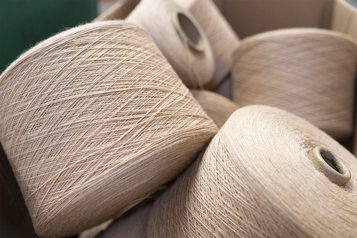 Close up of camel yarn cones stacked in box